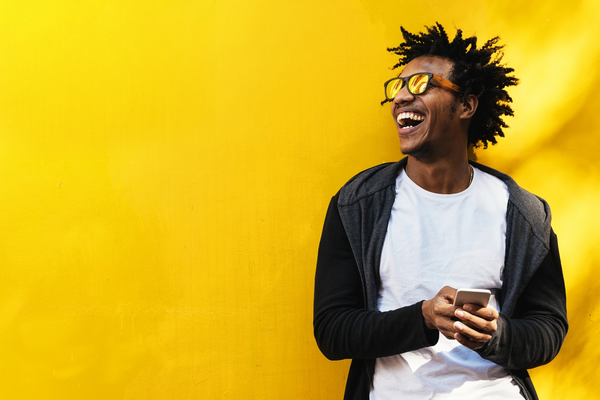 Man laughing while using his mobile phone