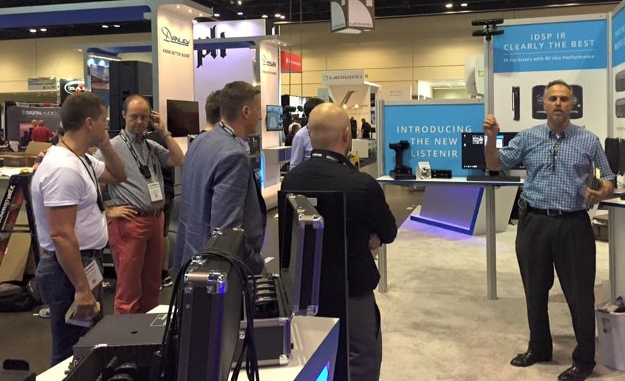 Attendees at a tradeshow listening to presenter.