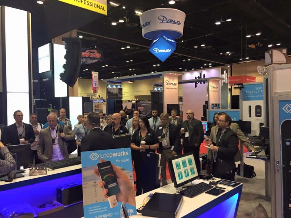 Listen Technologies booth at InfoComm 2015 with attendees visiting